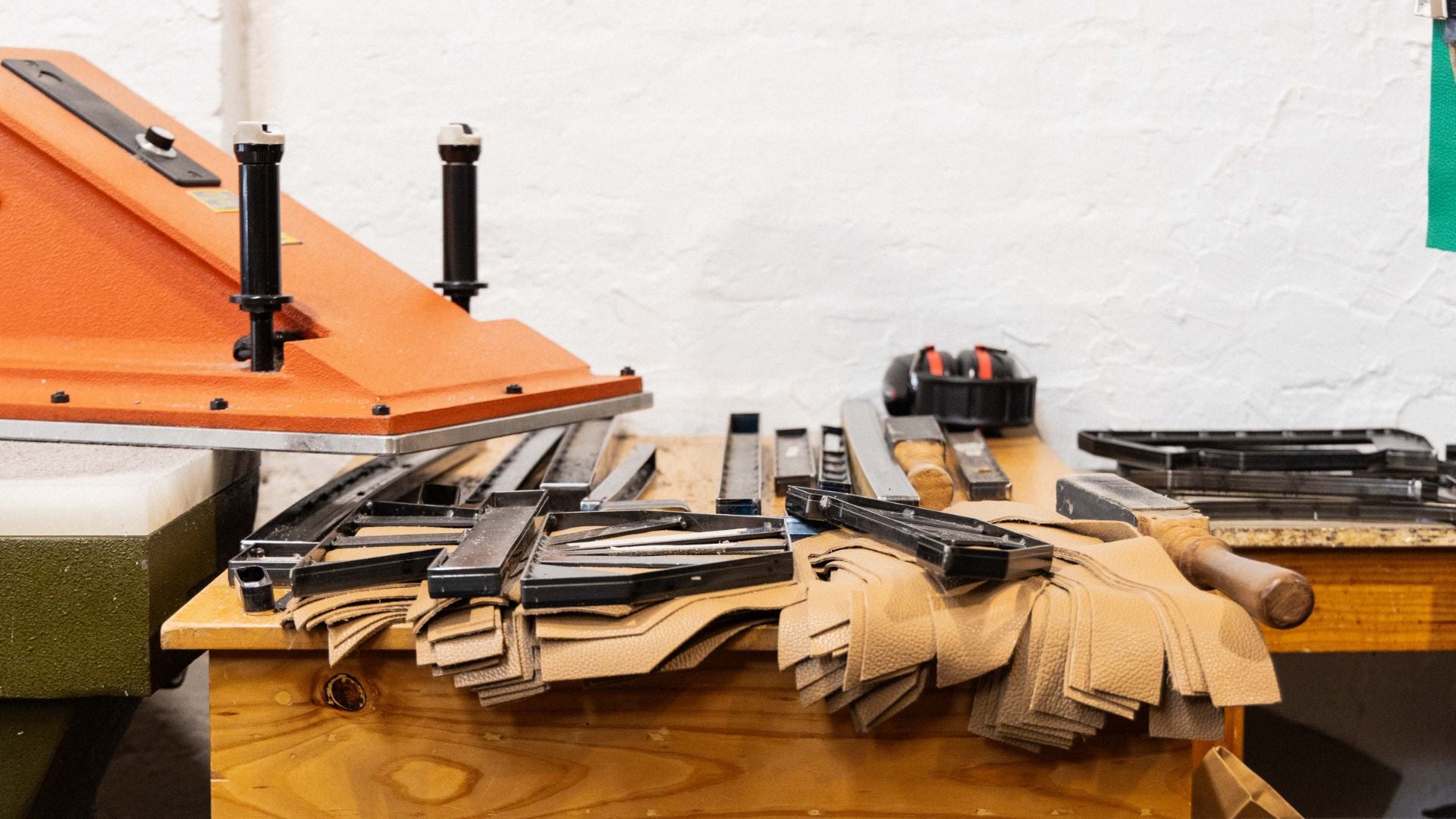 a stack of leather and tools on a bench at a-esque's studio