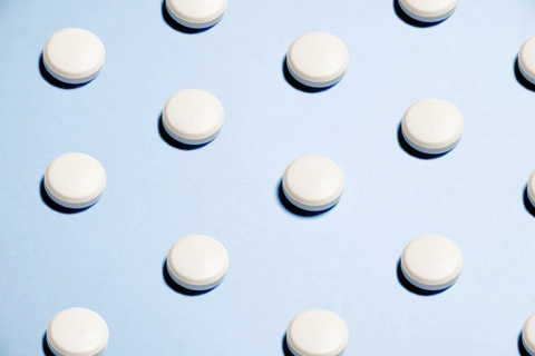 Round white pills on a blue background