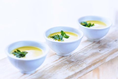 Three white bowls of leek soup