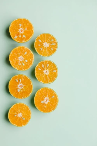 Sliced fresh oranges on a light green background