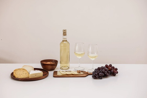 Wine in a bottle, grapes, and cheese
