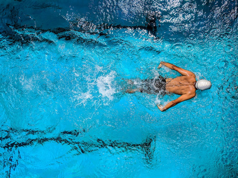 A person swimming in a lap pool