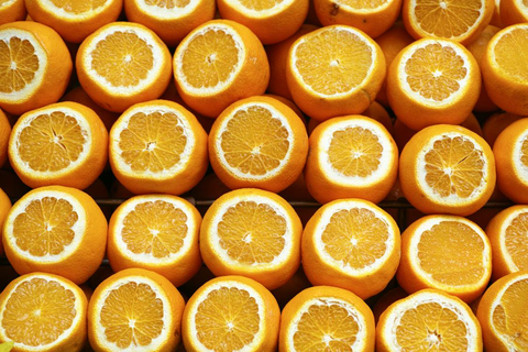 Many oranges with the tops sliced off