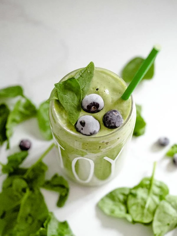 A green smoothie with blueberries on top