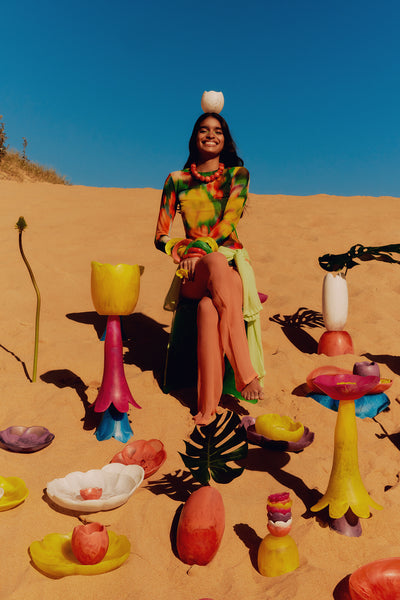 Flower-shaped resin homewares, and bold jewellery in bright colours on the beach.