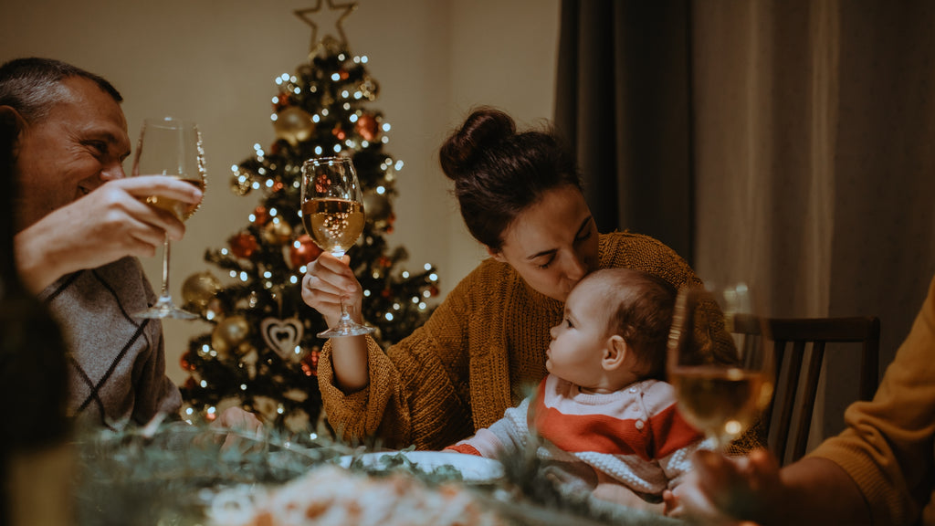 Papa und Mama mit Baby feiern Weihnachten, Familie beim Festtagsmenü, Weihnachtsbaum