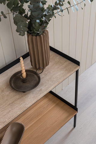 A console shelf with Travertine stone top, Steel black frame and light oak wood available to shop only from The Loom Collection in Dubai. The shelf has a vase with green euchaliptus plant and a cnadle in a candle holder. 