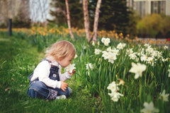 young child smelling flowers