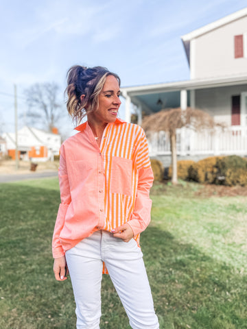 Neon orange button up shirt with white jeans