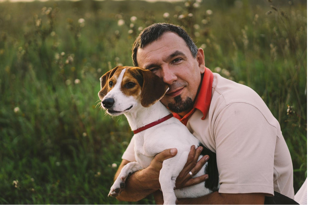 happy man cuddling jack russell terrier