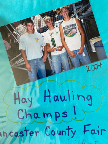 Colton and friend are hay hauling champs holding a trophy