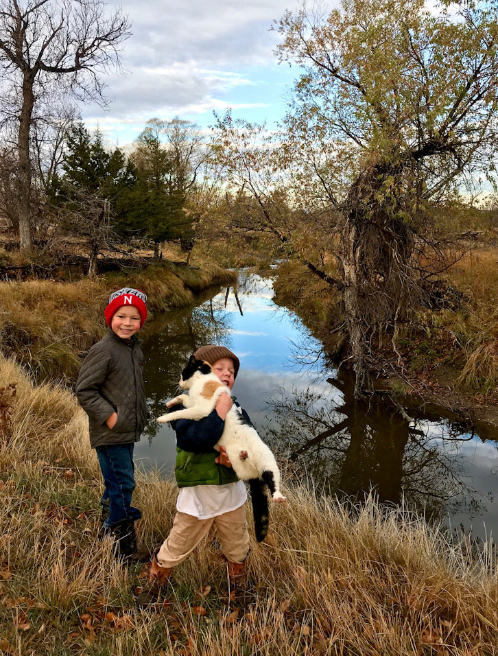 Lincoln and Barrett by a creek with a cat