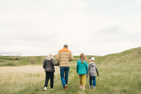 Wild Idea CEO Phil Graves walking with three kids on Cheyenne River Buffalo Ranch prairie