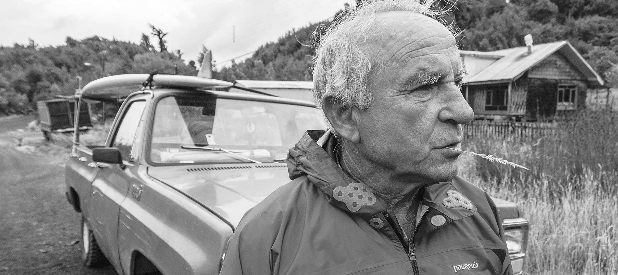 Black and white photo of yvon chouinard in front of old truck