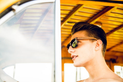 topless guy wearing black shades driving his vintage wagon