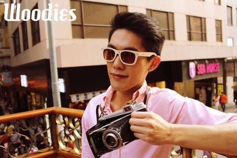 guy wearing white sunglasses holding a camera