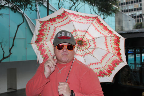 guy in sunglasses holding a pink umbrella