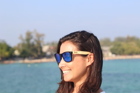 girl wearing wooden sunglasses in the shade of blue
