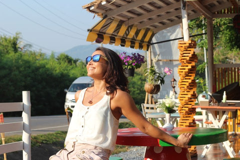 girl lounging under the sun wearing sunglasses