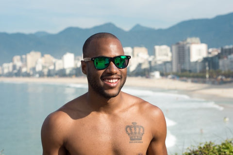 topless guy with crown tattoo on chest wearing wooden green shade sunglasses