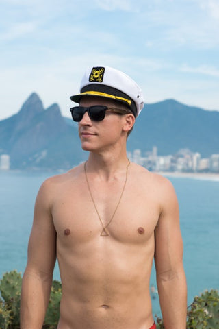 topless guy in captain's hat wearing wooden sunglasses in black shade