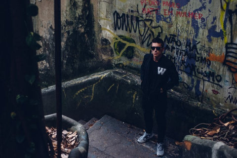 guy in an alley wearing all black with black sunglasses