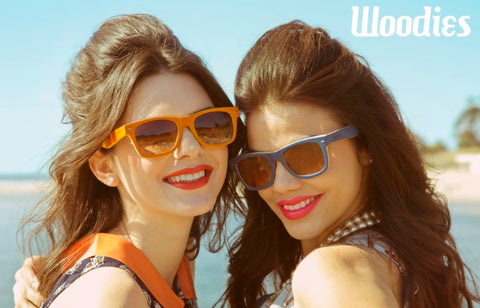 2 girls smiling wearing solild orange and solid blue sunglasses