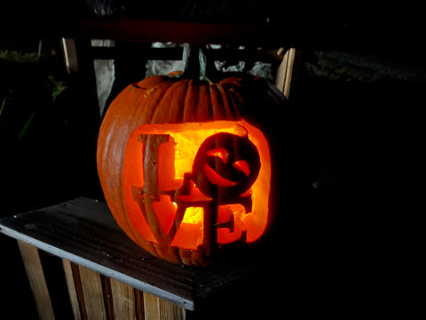 A pumpkin carved to say "love."