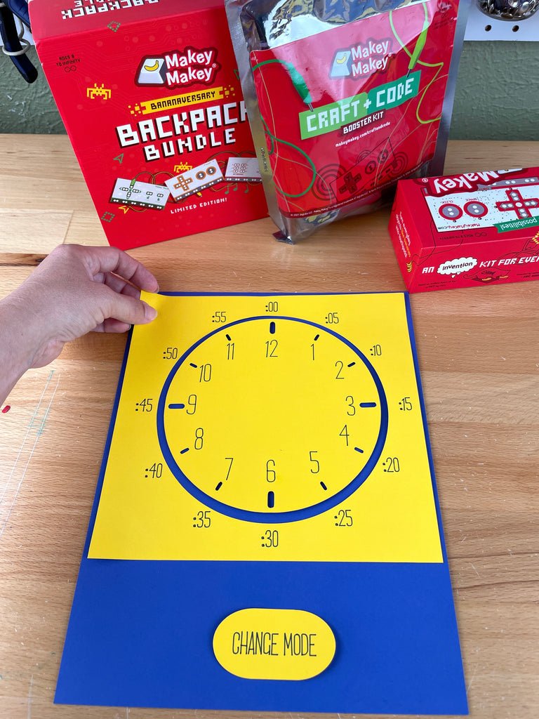 yellow clock face on cardstock being placed on blue cardstock