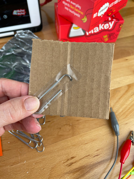 large end of paperclip on bottom of cardboard