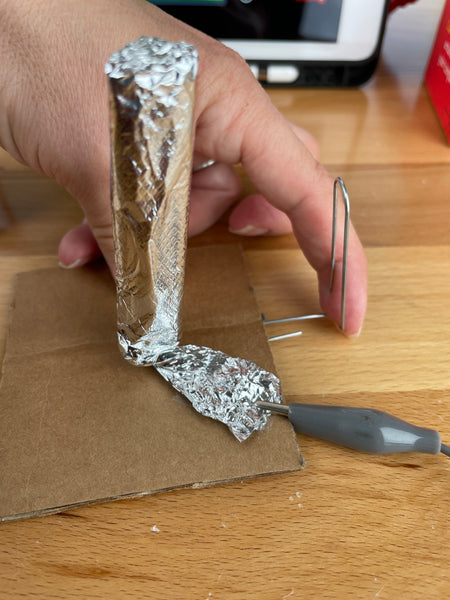 push paper clip into cardboard