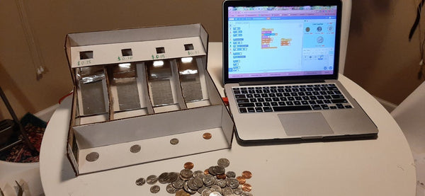 Cardboard coin counter with foil and computer