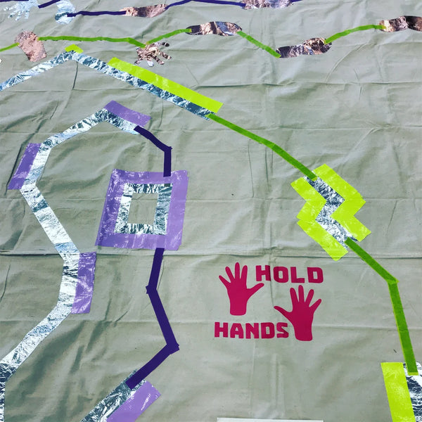 colorful maze with one purple path and one green path. The text says "Hold hands"