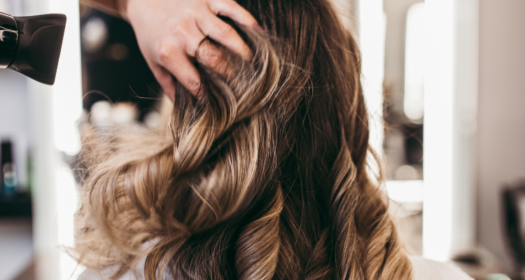 Stylist drying women's hair