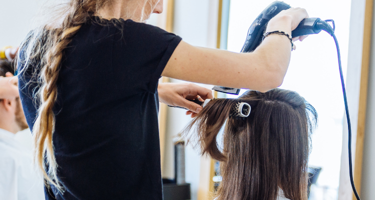 Stylist blow drying hair