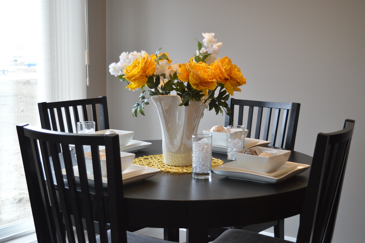 Caption: Flowers look and smell lovely in a staged house. Alt: Flowers in a vase on a table.