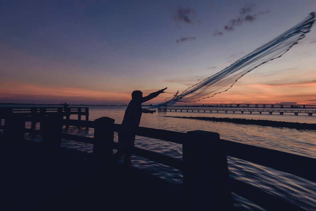 Night photo of Man throwing a fishing net