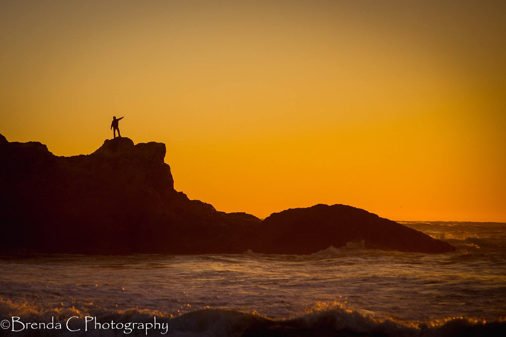 silhouette of man on the edge of cliff