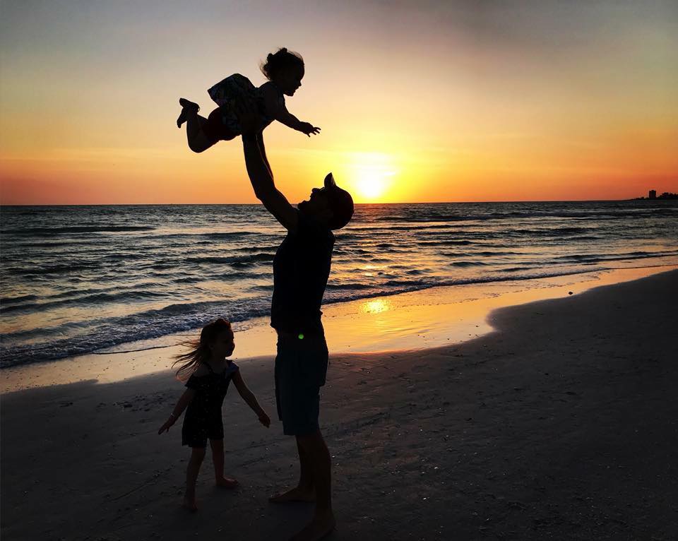 silhouette photo of father throwing child in the air