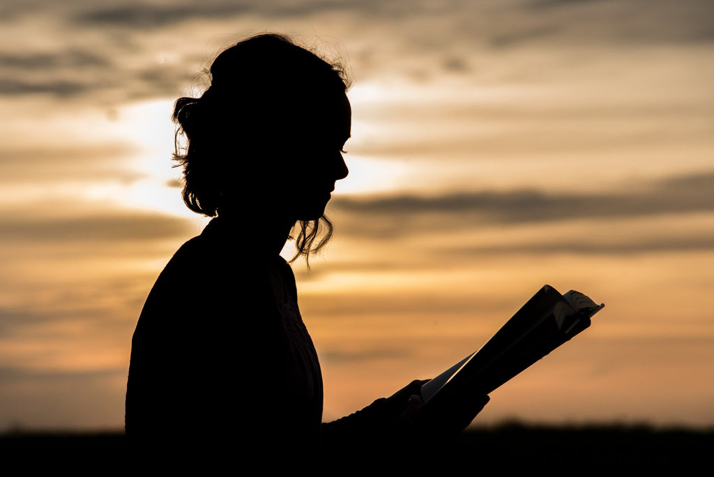 silhouette photograph of woman reading