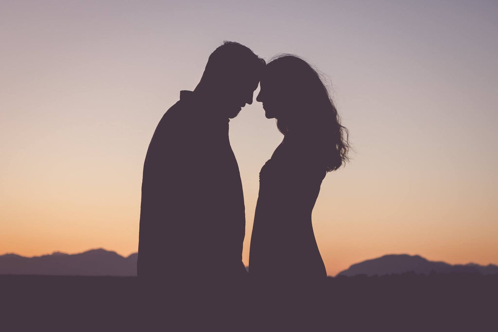 Silhouette of couple touching foreheads