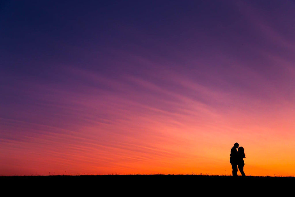 silhouette image of couple against beautifully colored sky