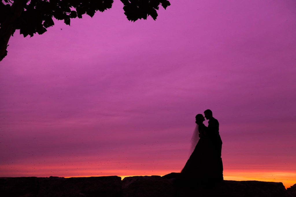 Silhouette photo of married couple with purple sky