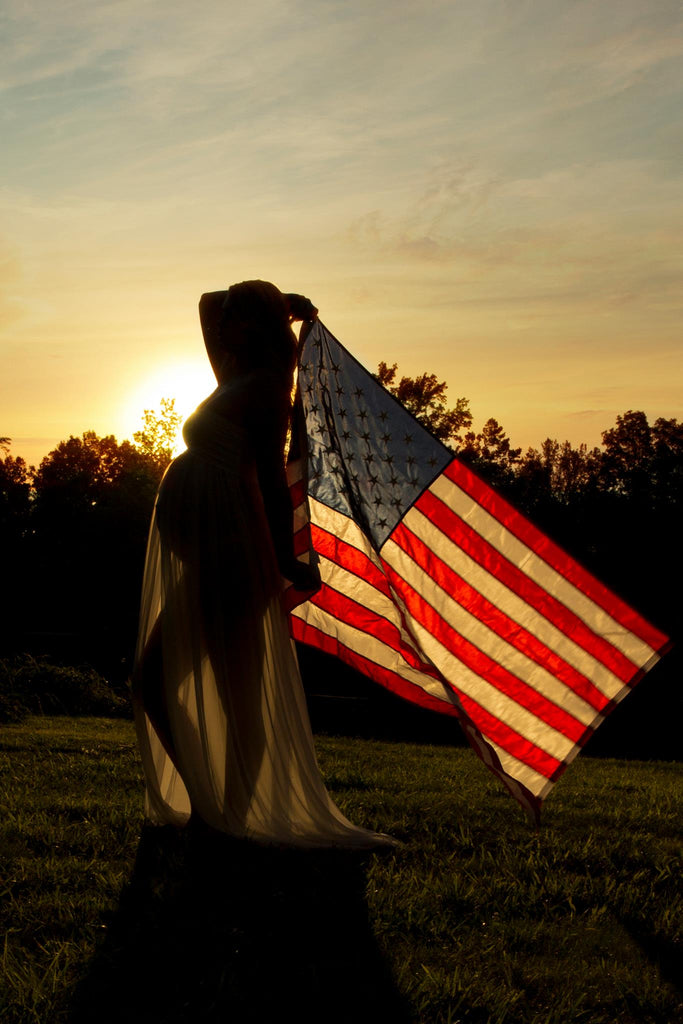 silhouette image of pregnant woman holding American flag