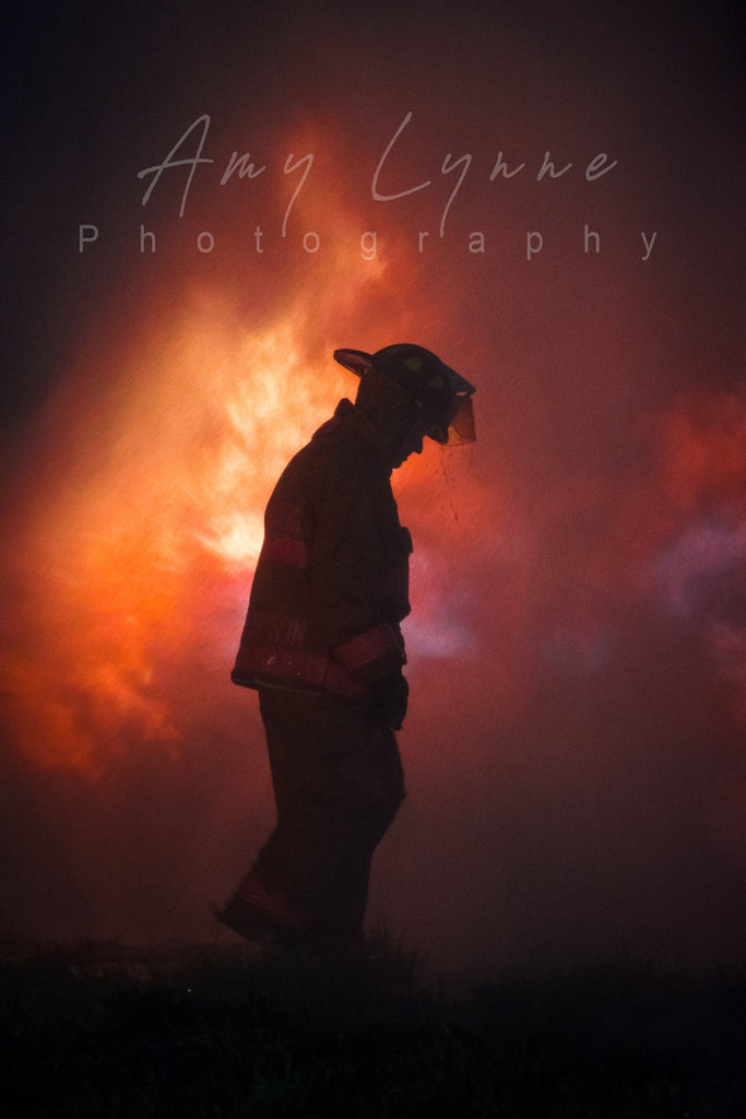 silhouette photo of firefighter in front of fire