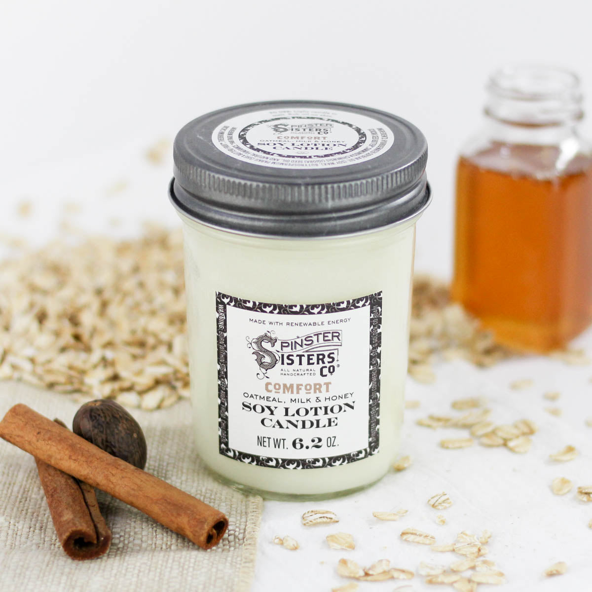 Oatmeal, Milk & Honey candle in a jar surrounded by its ingredients