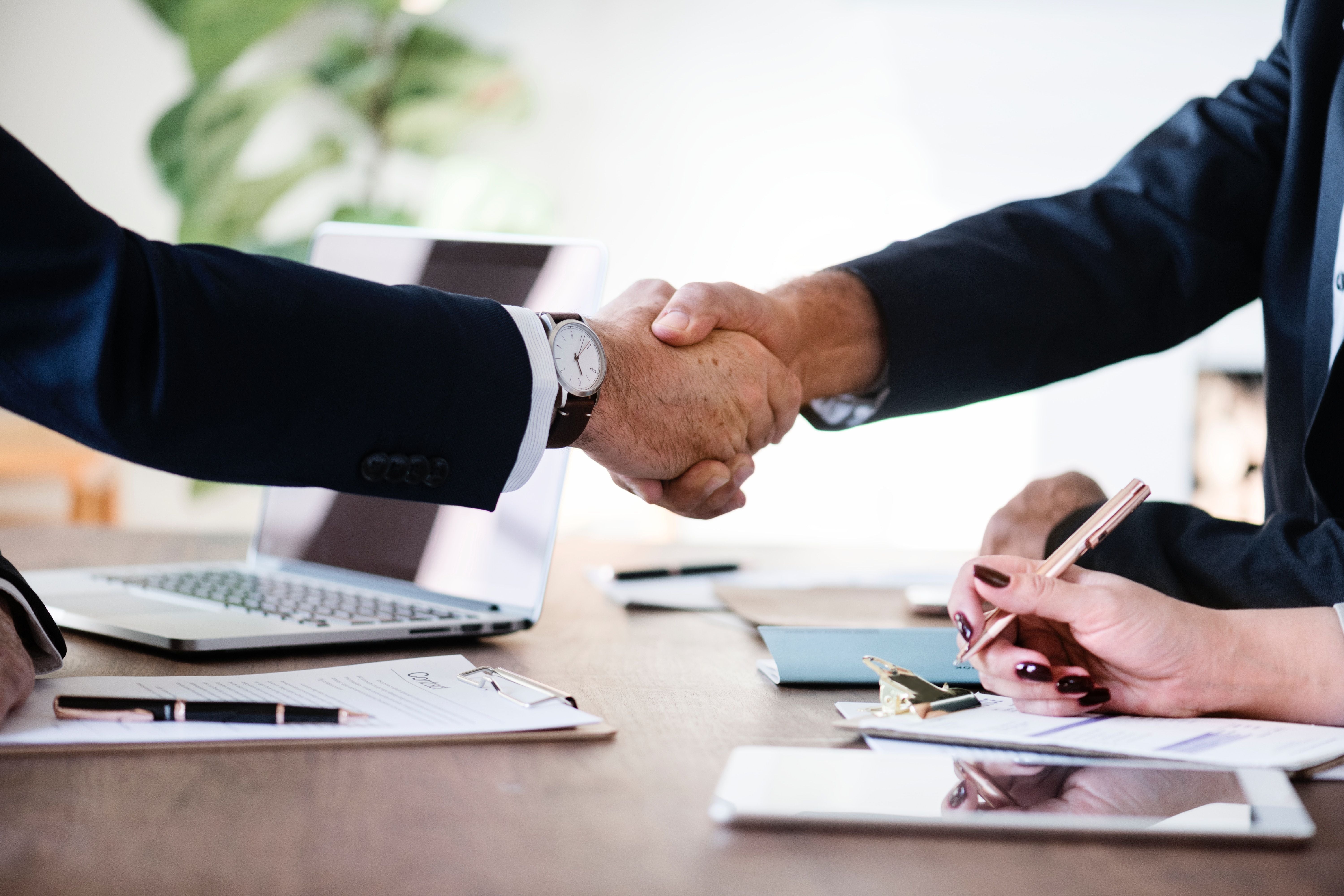 Two businessmen shaking hands in an interview