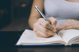 Student studying by writing in a notebook