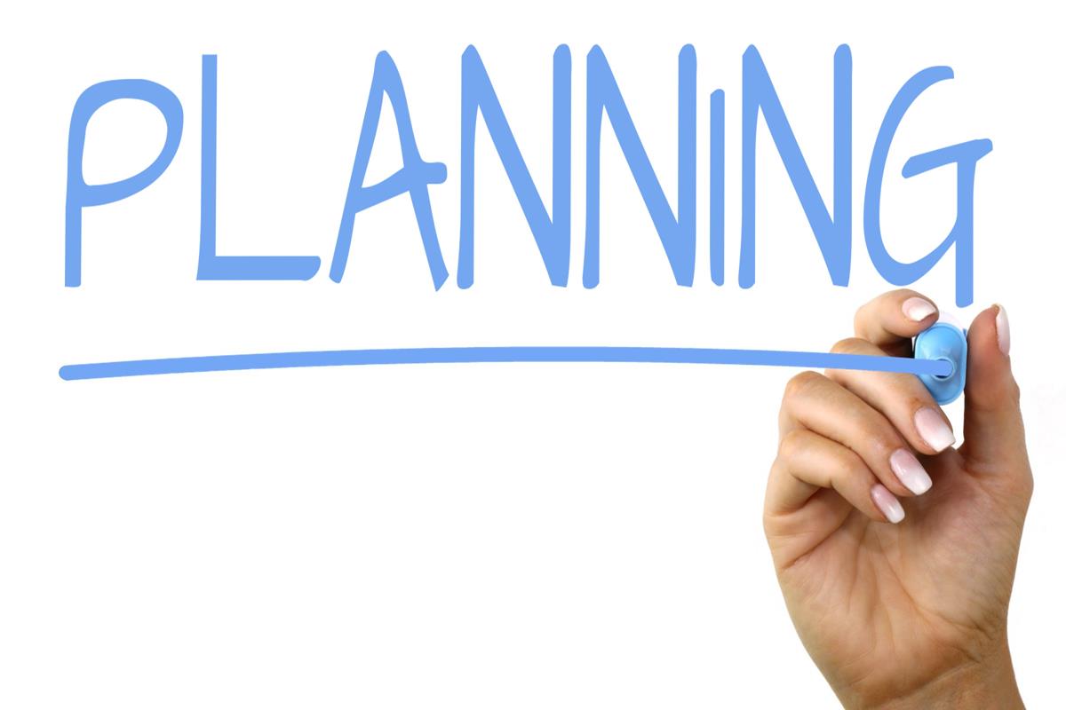 Hand writing the word 'planning'