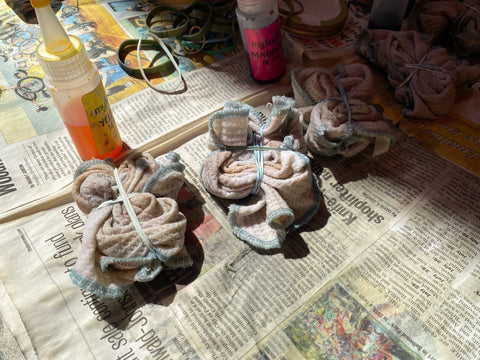 Rags are twisted in spirals and held with rubber bands, all prepped to be tie-dyed.